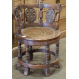 Anglo-Indian style swivel chair, the curved back with (3) carved floral reserves, over a circular