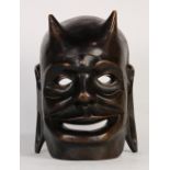 Southeast Asian carved wood mask, of a mythical creature with horns and long ear lobes with holes,