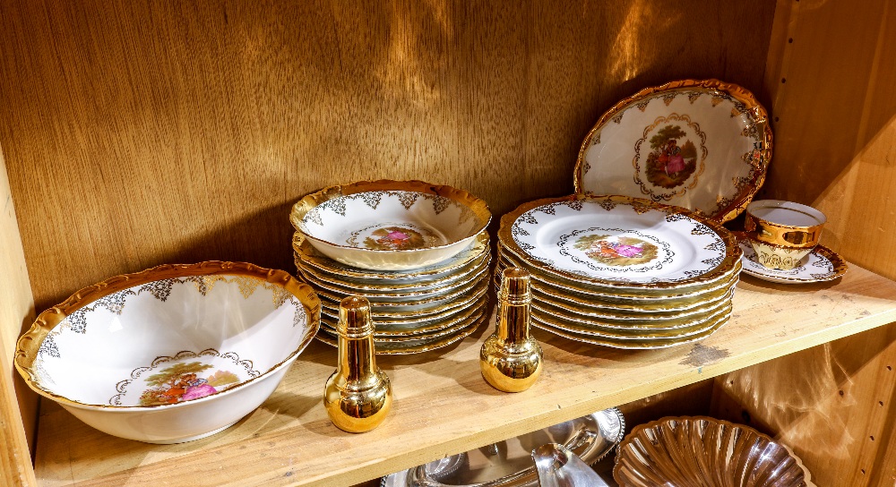 One shelf of a partial gilt Bavarian table service, each having a scenic decorated central