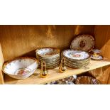 One shelf of a partial gilt Bavarian table service, each having a scenic decorated central