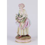 Meissen polychrome decorated figural group, depicting a flower seller, dressed in Classical