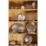 Four shelves of silver plate, including lidded serving tureens, platters, a coffee pot, etc.