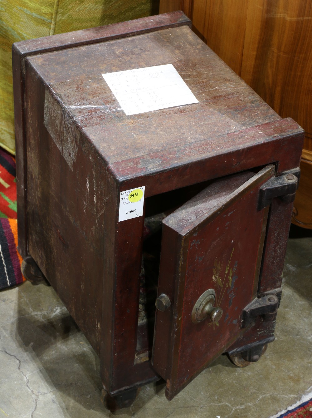 Victorian cast iron safe, having a hinged door with tole painted floral reserves, the whole rising