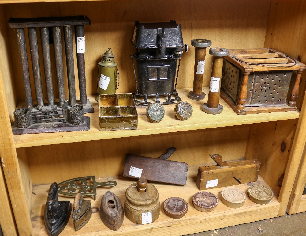 (lot of 21) Two shelves of primitive tools, including a candle mold, cast iron irons, wood butter