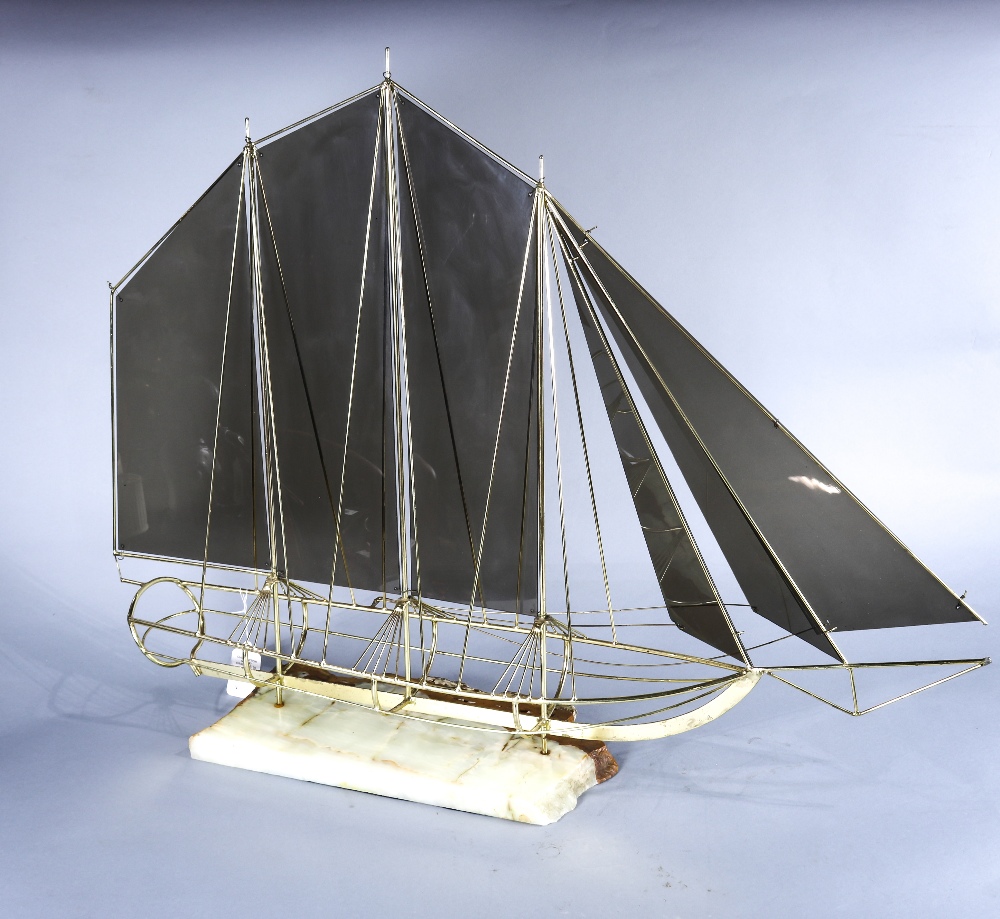 Mid century modern brass sail boat sculpture, the sails executed in smoked gray plastic, rising on a