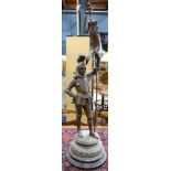 Patinated metal figural sculpture of a knight, carrying a banner, wearing armor, and rising on a