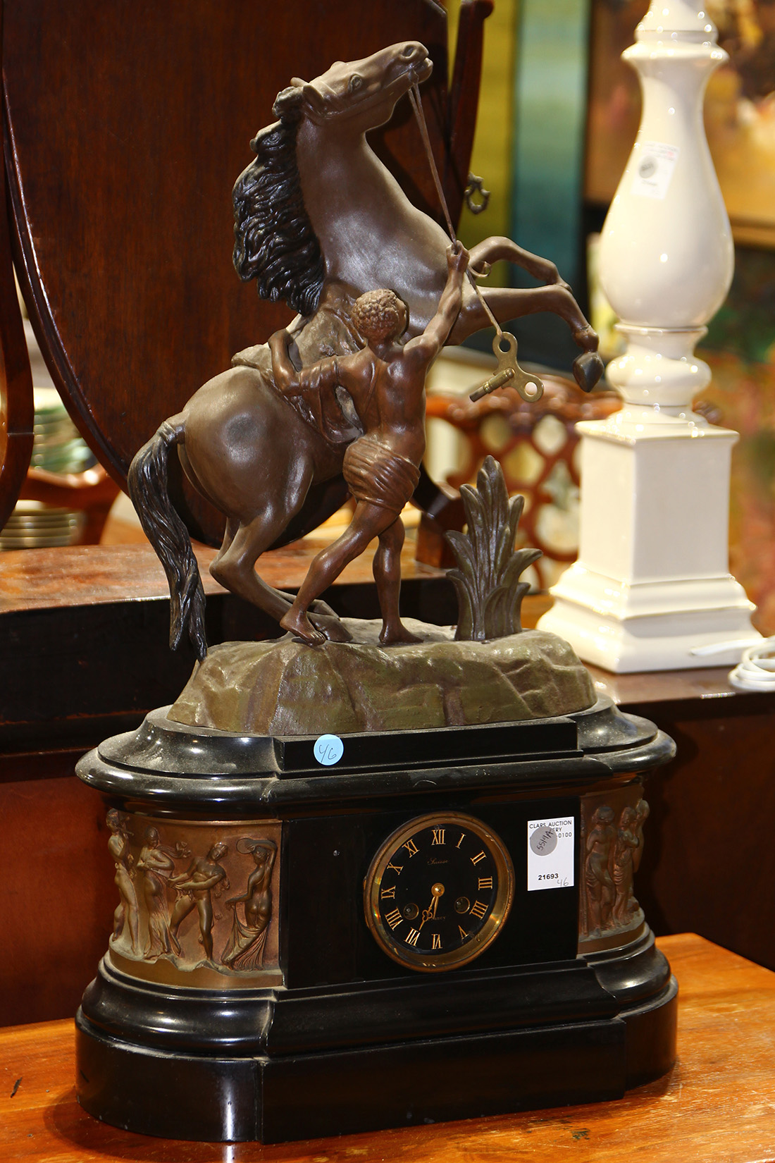 Neoclassical revival style figural mantle clock, the clock surmounted by a patinated spelter male