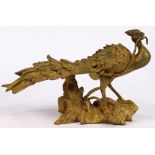 Viennese style gilt bronze peacock statue, the stylized bird holding a blooming flower, the whole