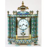 French style champleve decorated mantle clock, having a floral decorated case with beveled glass