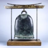 Indian bronze bell, with a zig-zag pattern to the base of the handle, suspending from stand,