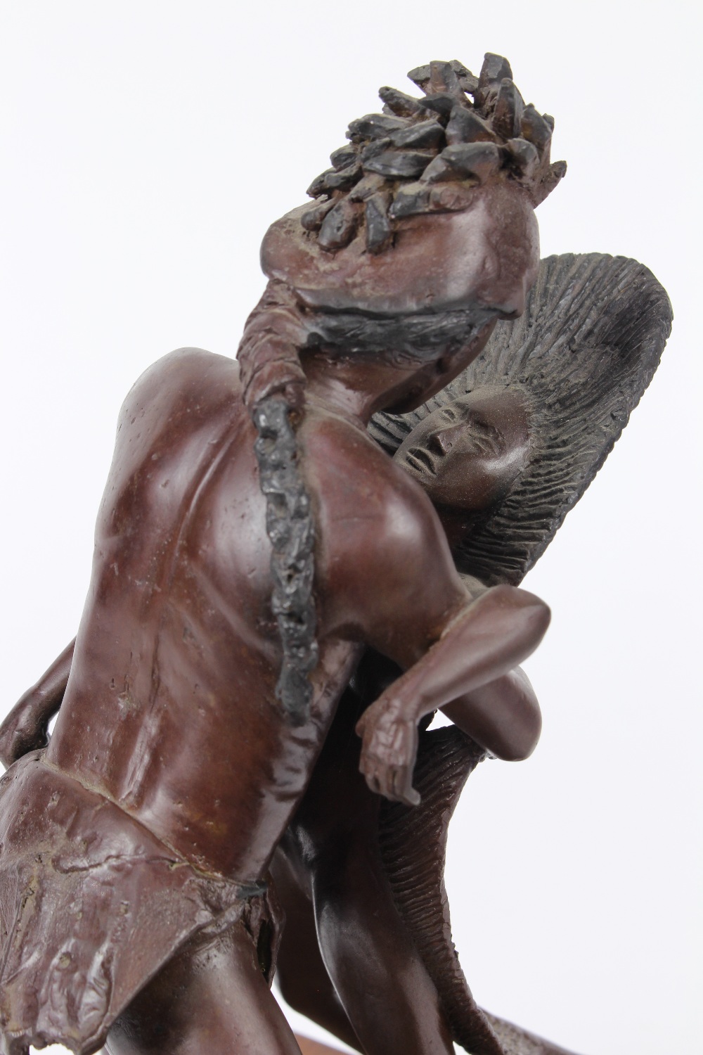 Patinated bronze Native American figure, modeled as embracing a feather girl, rising on a wood base, - Image 4 of 4