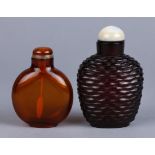(lot of 2) Chinese glass snuff bottles: one amber color with a flattened round body; the other of