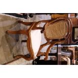 Victorian caned back armchair, having a shape caned back, with scrolled arms and rising on