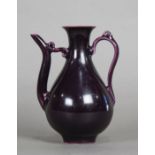 Chinese aubergine glazed porcelain ewer, with a pear shaped body and long curved spout and handle,