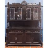 Late Victorian ebonized buffet, having a leaded glass superstructure above the four door lower