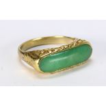 Jadeite and 14k yellow gold ring Featuring (1) jadeite saddle, measuring approximately 20 x 6 mm,