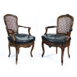 Pair of Louis XV style fauteuils, each having a floral decorated crest, above a cane back,