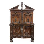 Continental carved court cabinet, early 18th century, having a broken pediment top, centered with