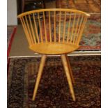 Mid Century arm chair, having an even arm back with spindle supports, and rising on tapered legs,