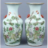 Pair of Chinese porcelain vases, each enameled with children playing in a garden carrying a pot of