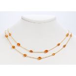 Garnet and 18k yellow gold necklace featuring (27) oval-cut yellow garnets, weighing a total of