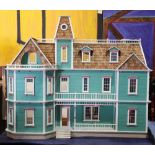 Victorian style dollhouse, having (10) unfinished interior rooms, with a green and pink decorated