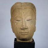 Thai Ayutthaya style sandstone Buddha head, the serene face with arching eyebrows framing the down