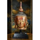 Southeast Asian gilt lacquered Buddha head, with a red lacquered face below a coiffure of small