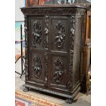 Continental ebonized cabinet, late 19th century, having floral carved doors, and rising on paw feet,