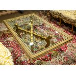 Hollywood Regency style cocktail table, having a gilt border surrounding the glass top and rising on