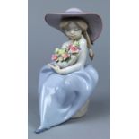 Lladro female figurine, modeled as a seated female holding a polychrome floral bouquet in her