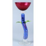 Contemporary blown art glass "Elijah's Cup", the cranberry glass bowl resting on the blue and