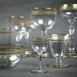 Four shelves of Continental crystal stemware, all having a gilt rim, with a gilt border flanked on