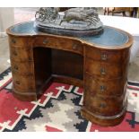 Kidney-form knee hole desk, the leather tooled top above the 9-drawer case, rising on cabriole legs,