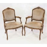 Pair of Louis XV style fauteuils, each having a carved crest with tan upholstery with brass nail