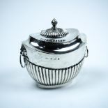 English sterling silver tea caddy, 1906, with an oval flattened body flanked by lion masks and loose
