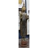 Thai large gilt wood Buddha, in monastic robe and hands in abhaya mudra, standing above a red