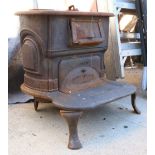 Iron wood burning stove, rising on a footed base, 22"h x 20"w