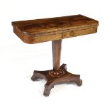 Regency rosewood games table, having a highly figured flip top with brass string banding, above