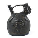 Chimu press molded blackware effigy stirrup vessel, Peru (1200 - 1476 AD), with a depiction of a
