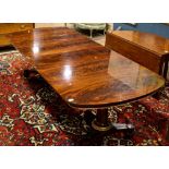 French Empire style mahogany double pedestal dining table, having a rounded top, above partial