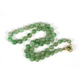 Jadeite and 14k yellow gold necklace Composed of (47) jadeite beads, ranging in size from