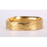 14k yellow gold bracelet The 14k yellow gold, engraved bangle, measures approximately 12.7 mm in
