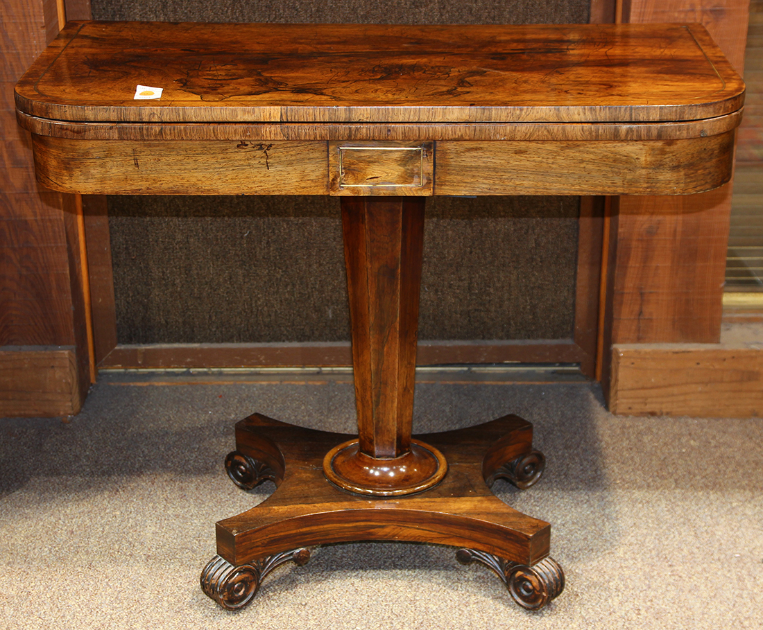 Regency games table, having a highly figured rosewood flip top above the faceted standard and rising