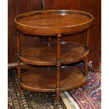 Edwardian style three tier occasional table, having an oval form the turned supports conjoining each