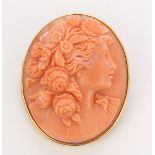 Coral cameo and 14k yellow gold brooch Featuring (1) oval carved coral cameo, depicting the bust