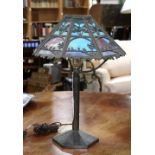 Arts and Crafts metal overlay boudoir lamp, having a slag glass shade with metal overlay depicting a