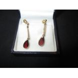 A pair of 9ct gold screw on earrings set with garnets