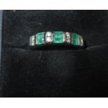 A 14ct white gold half hoop ring set with diamonds & emeralds