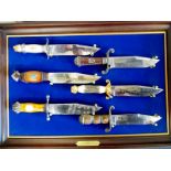 A collection of Bowie knives mounted on a framed board